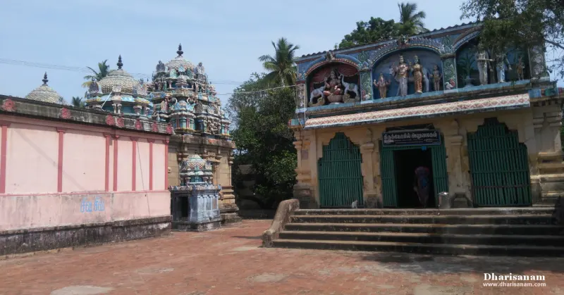Paved courtyard with a shrine entrance at right and tiered towers behind the wall