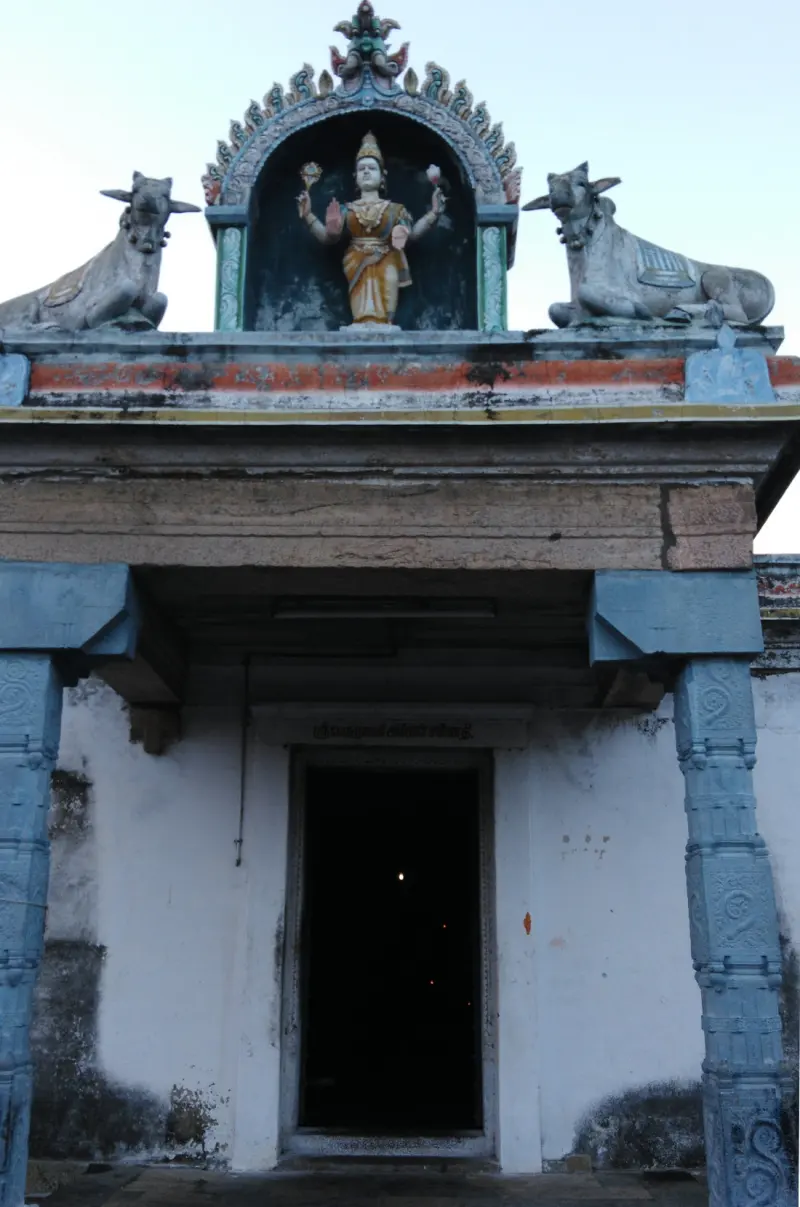 Pillared shrine entrance with a standing goddess figure between two bulls