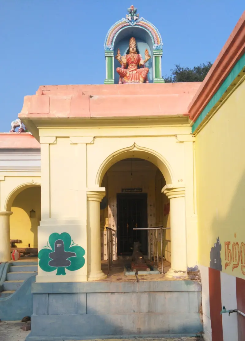 An arched yellow entrance crowned with a seated goddess