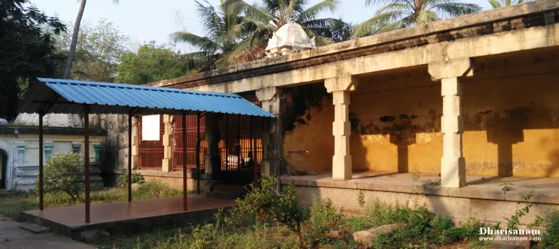 Stone pillars, grilled enclosures, and a blue-roofed shelter under palms