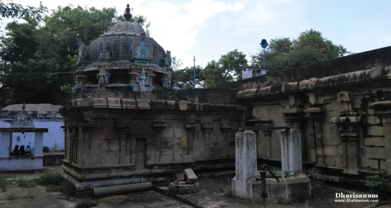 A domed tower with small figures above a granite wall, with two stone posts in the foreground
